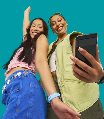 2 women looking at a phone happily.